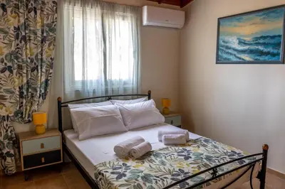 a bedroom with a bed with two towels on it at G & M Beach House in Haraki