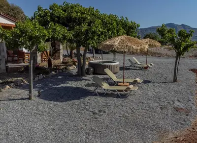 a group of chairs and umbrellas on a beach at G & M Beach House in Haraki