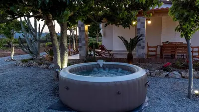 a hot tub in the yard of a house at G & M Beach House in Haraki