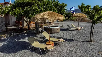 a group of chairs and umbrellas on a beach at G & M Beach House in Haraki
