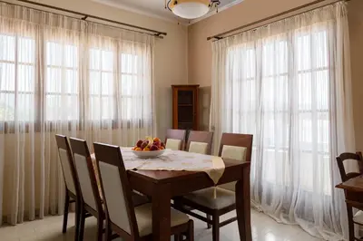 a dining room table with chairs and a bowl of fruit on it at Green Sunshine in Theologos
