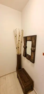 a room with a mirror and a vase with sticks at Green Sunshine in Theologos