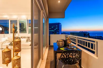 a balcony with a table and a view of the city at Unique Sea & Sunset Residence in Ixia
