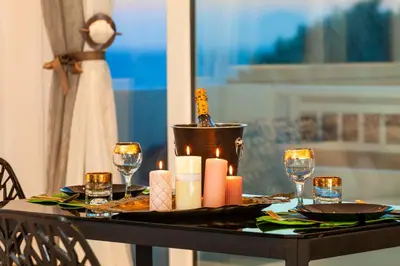 a table with candles and wine glasses on it at Unique Sea & Sunset Residence in Ixia