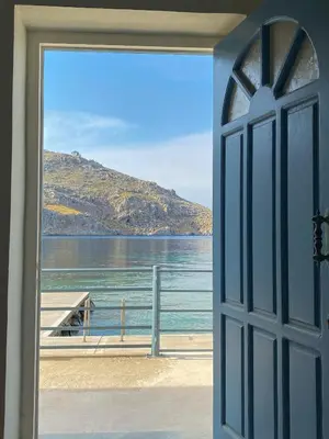 an open door with a view of the water at Ponente in Symi