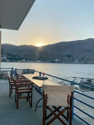 a table and chairs sitting on the deck of a boat at Ponente in Symi