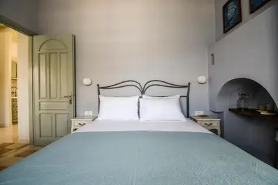 a bedroom with a large bed with two white pillows at Ponente in Symi