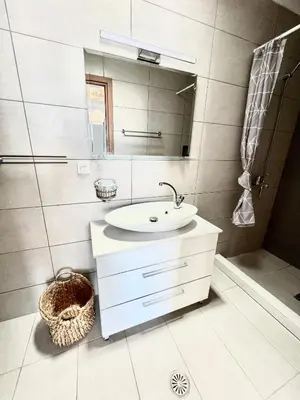 a white bathroom with a sink and a mirror at Vaso Beach Front Villa in Ialyssos