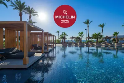 a pool at a resort with a sign that reads mitzlin at Ammades All Suites Beach Hotel & Spa - Adults Only in Faliraki