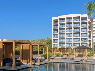 a hotel with a swimming pool and a building at Ammades All Suites Beach Hotel & Spa - Adults Only in Faliraki