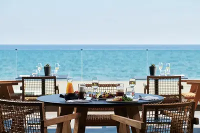 a table with a plate of food on the beach at Ammades All Suites Beach Hotel & Spa - Adults Only in Faliraki
