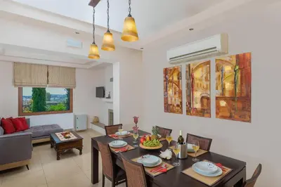 a dining room and living room with a table and chairs at Majestic View Villa in Kolimbia