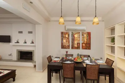 a dining room with a table and chairs and a fireplace at Majestic View Villa in Kolimbia