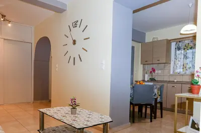 a kitchen and dining room with a clock on the wall at Lana's House in Rhodes Town