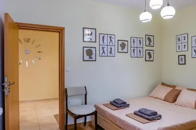 a bedroom with a bed and a chair and a clock at Lana's House in Rhodes Town