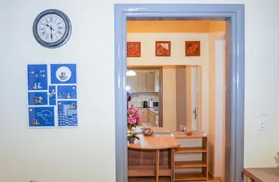 a kitchen with a table and a clock on a wall at Lana's House in Rhodes Town