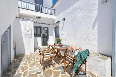 a small patio with a wooden table and chairs at Traditional Dream House in Soroni