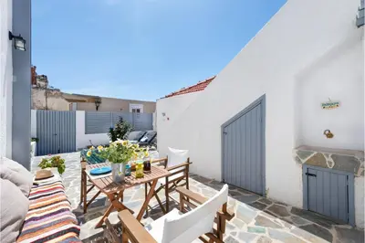 a patio with a table and chairs and a building at Traditional Dream House in Soroni