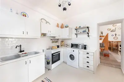 a kitchen with white cabinets and a sink and a dishwasher at Traditional Dream House in Soroni