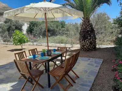 a wooden table with chairs and an umbrella at Annika's Summer Dream in Livadia