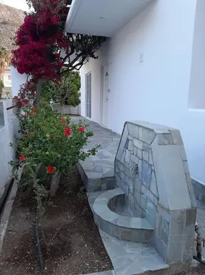 a stone bench in front of a house with flowers at Annika's Summer Dream in Livadia