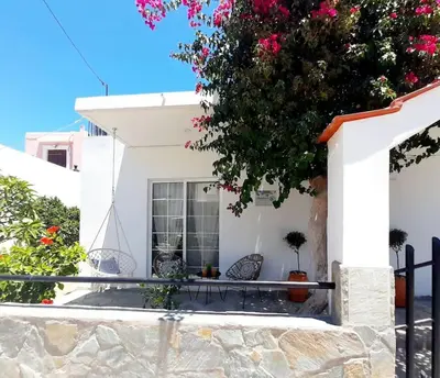 a white house with two chairs and a tree at Annika's Summer Dream in Livadia