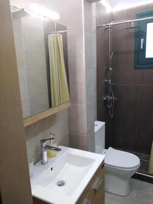 a bathroom with a sink and a toilet and a shower at Serafi Cozy Rooms in Archangelos