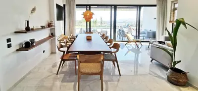 a dining room with a long table and chairs at Maison A Rhodes with 66m2 heated pool on a 4800m2 plot in Koskinou