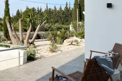 a patio with chairs and a garden with trees at Maison A Rhodes with 66m2 heated pool on a 4800m2 plot in Koskinou