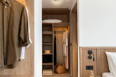 a bedroom with a closet with a robe and a bed at Maison A Rhodes with 66m2 heated pool on a 4800m2 plot in Koskinou