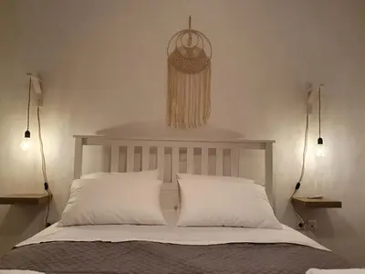 a bedroom with a bed with two pillows and two lights at Kalavarda Cosy Home 2 in Kalavárda