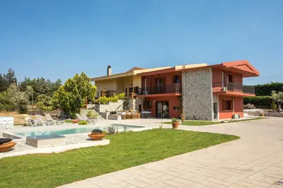a house with a swimming pool in front of it at Wine & Vineyard Retreat Emarmene in Koskinou