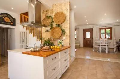a kitchen with white cabinets and a counter top at Wine & Vineyard Retreat Emarmene in Koskinou