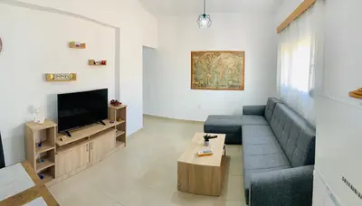 a living room with a blue couch and a tv at Escape Rooms in Afantou