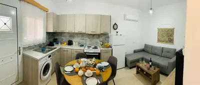a kitchen and living room with a table and a couch at Escape Rooms in Afantou