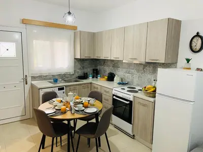 a kitchen with a table and a white refrigerator at Escape Rooms in Afantou