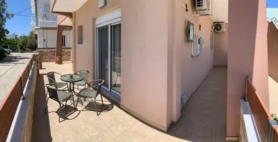 two chairs and a table on the balcony of a building at Escape Rooms in Afantou