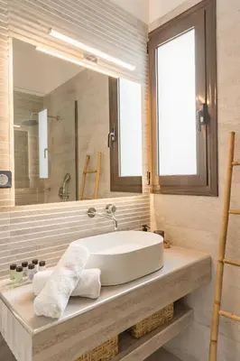 a bathroom with a sink and a large mirror at Villa Santa Maria with private pool and sea view in Afantou