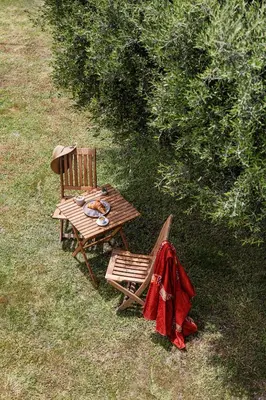 a wooden picnic table and chair with a red jacket on it at Villa Santa Maria with private pool and sea view in Afantou