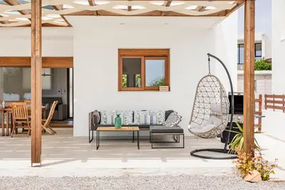 a patio with a couch and a chair at Villa Santa Maria with private pool and sea view in Afantou