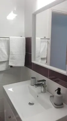 a bathroom with a sink and a mirror and towels at Kalavarda Cosy Home 1 in Kalavárda