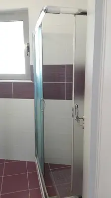 a shower with a glass door in a bathroom at Kalavarda Cosy Home 1 in Kalavárda