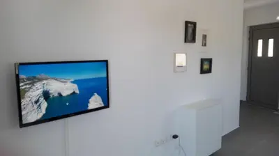 a flat screen tv hanging on a white wall at Kalavarda Cosy Home 1 in Kalavárda
