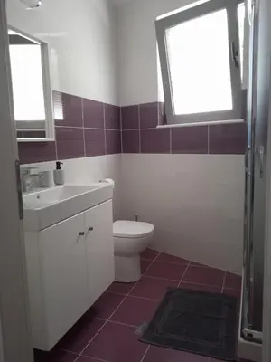 a bathroom with a toilet and a sink and a window at Kalavarda Cosy Home 1 in Kalavárda