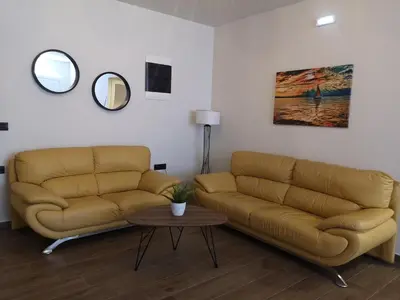 a living room with two couches and a table at SUNNY HOLIDAYS APARTMENT in Kremasti