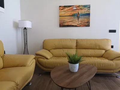 a living room with a couch and a table at SUNNY HOLIDAYS APARTMENT in Kremasti