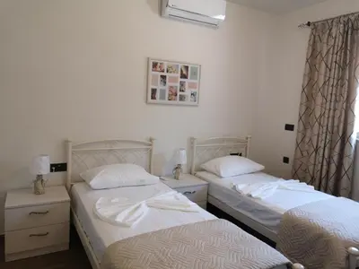 two twin beds in a room with a window at SUNNY HOLIDAYS APARTMENT in Kremasti