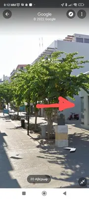 a screenshot of a street with a tree and buildings at Aegean Living in Rhodes Town