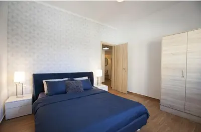 a bedroom with a blue bed and a white wall at Great Living in Rhodes Town