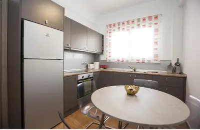 a kitchen with a table and a white refrigerator at Great Living in Rhodes Town